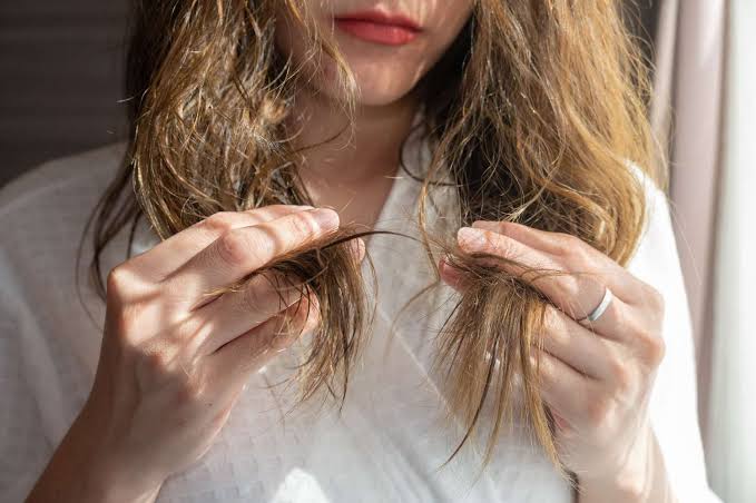 girl holding her protein overloaded hairs.